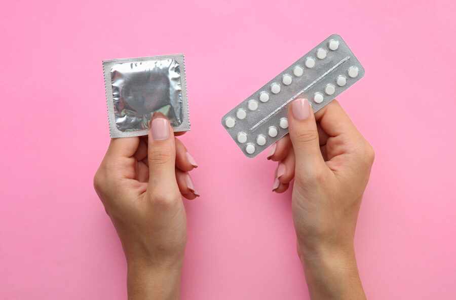 презерватив и таблетки в руках